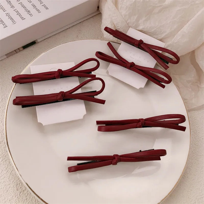 Wine red leather bow hair barrettes showing front and back views