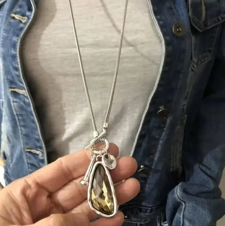 Long alloy sweater chain necklace with a geometric water drop pendant on a snake bone chain.