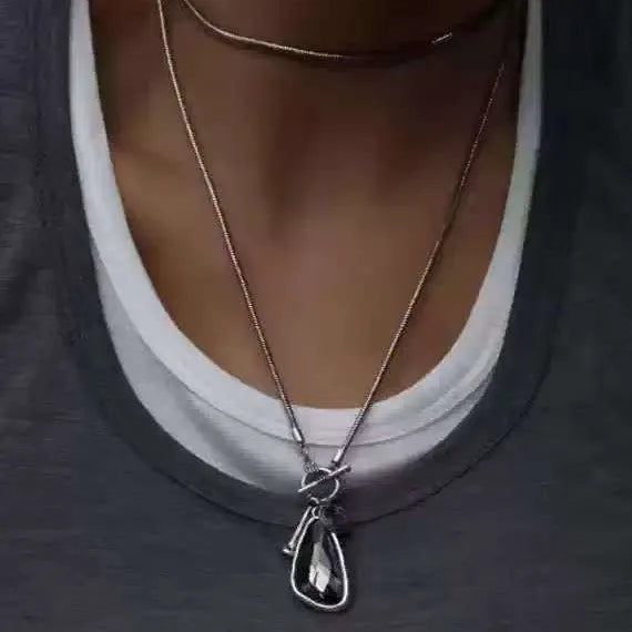 Long alloy sweater chain necklace with a geometric water drop pendant on a snake bone chain.