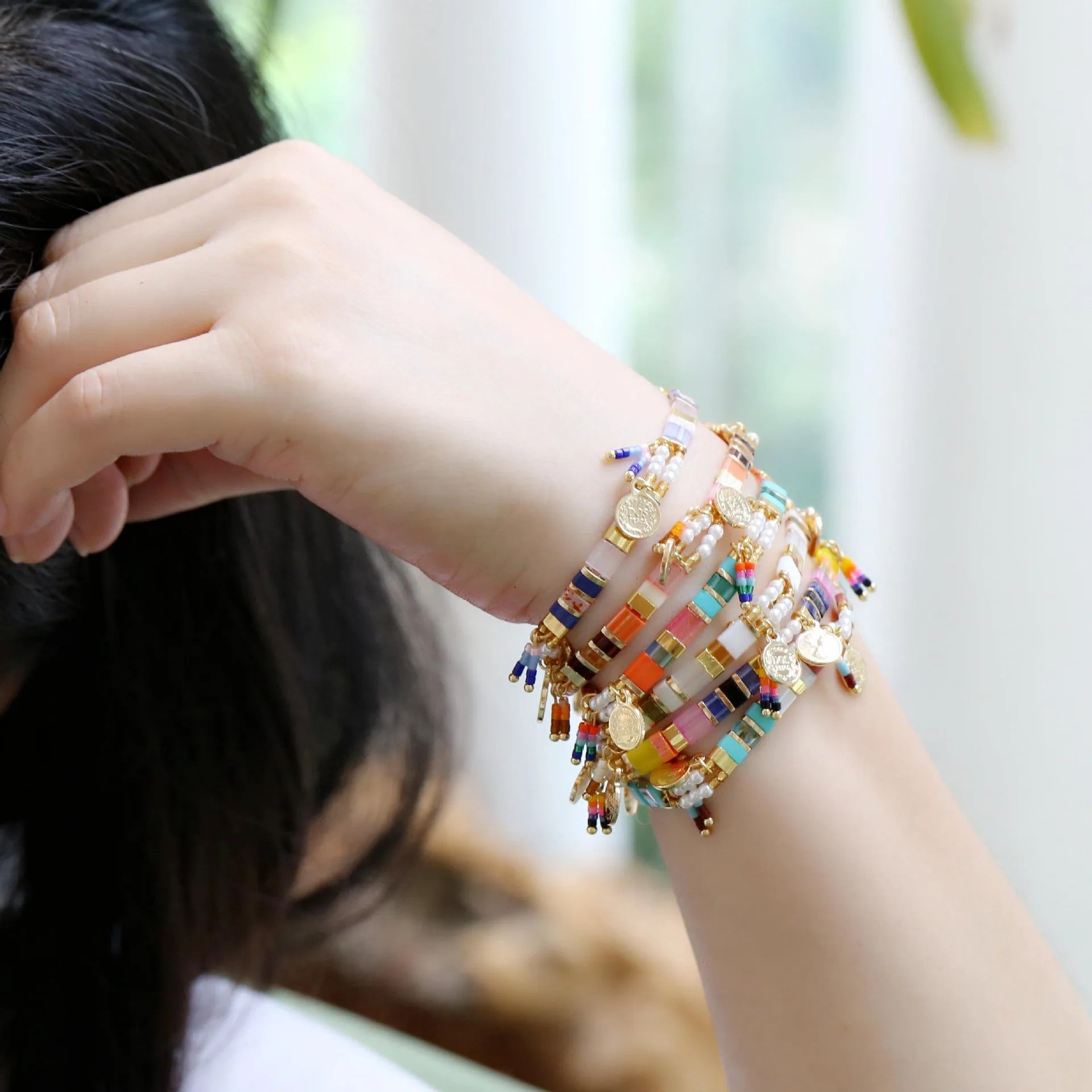Women's adjustable bracelet with imitation pearls and coloured glass beads in a European design.