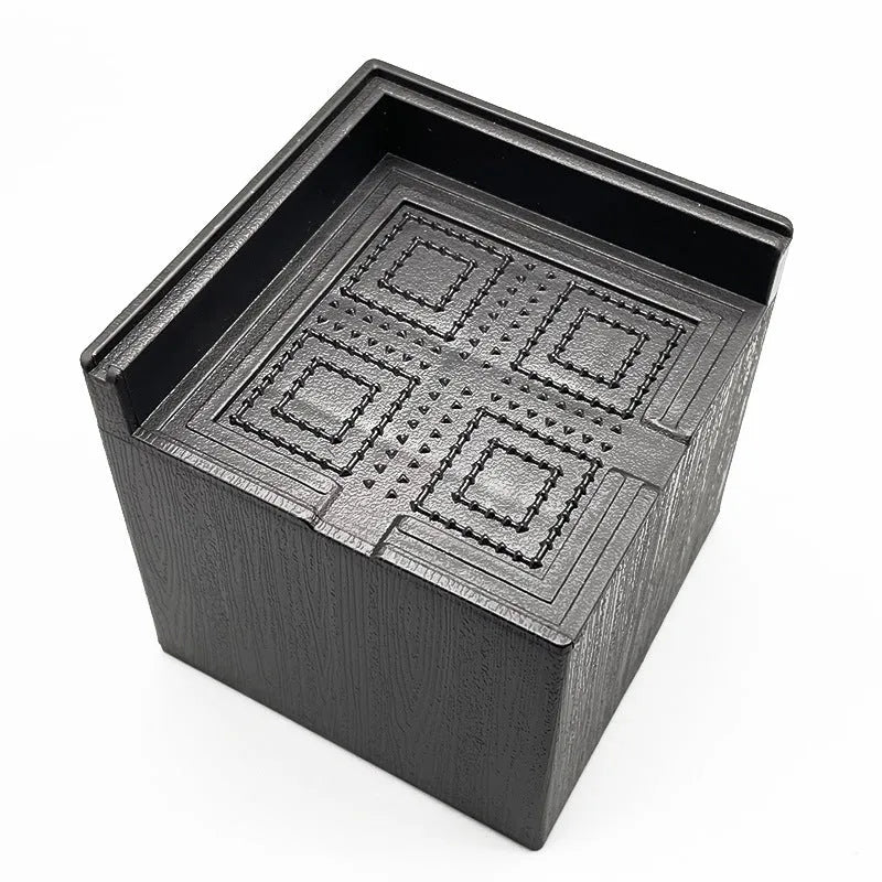 Four black thickened plastic bed foot mats arranged together for furniture height increase and floor protection
