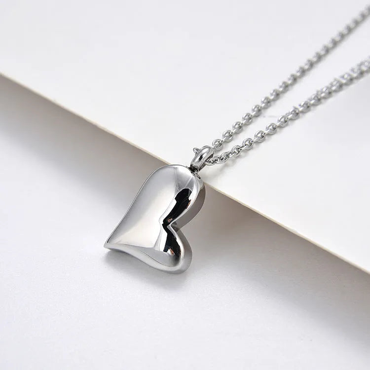Silver curved peach heart pendant on a stainless steel necklace with extension chain