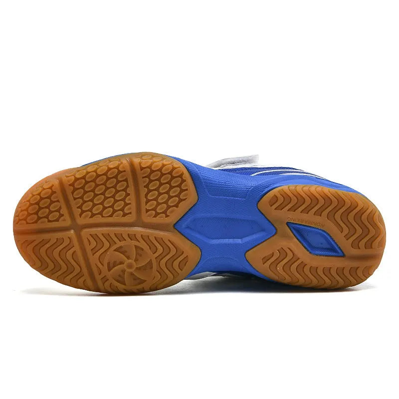 White and blue low-top breathable badminton shoes with ribbed sole on a court surface.
