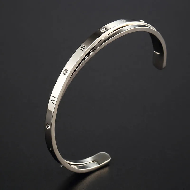 Open-ended stainless steel women's bracelet with inlaid zirconia stones in rose gold colour.
