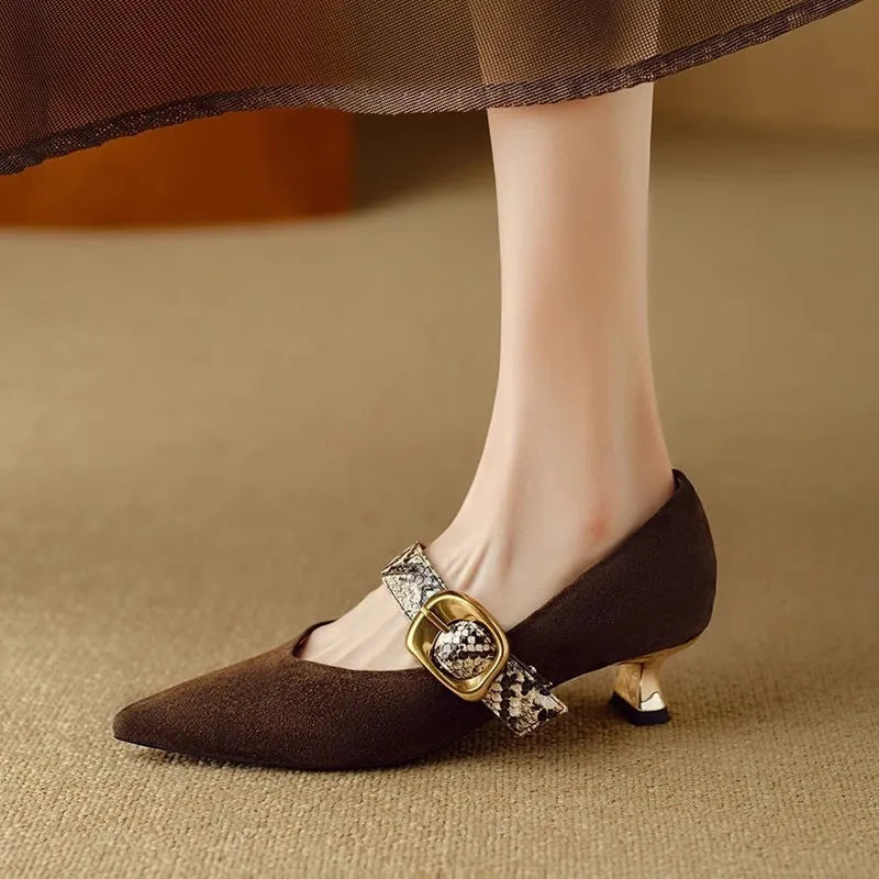 Black women's stiletto high heel shoes with buckle fastening and pointed toe on a solid background.