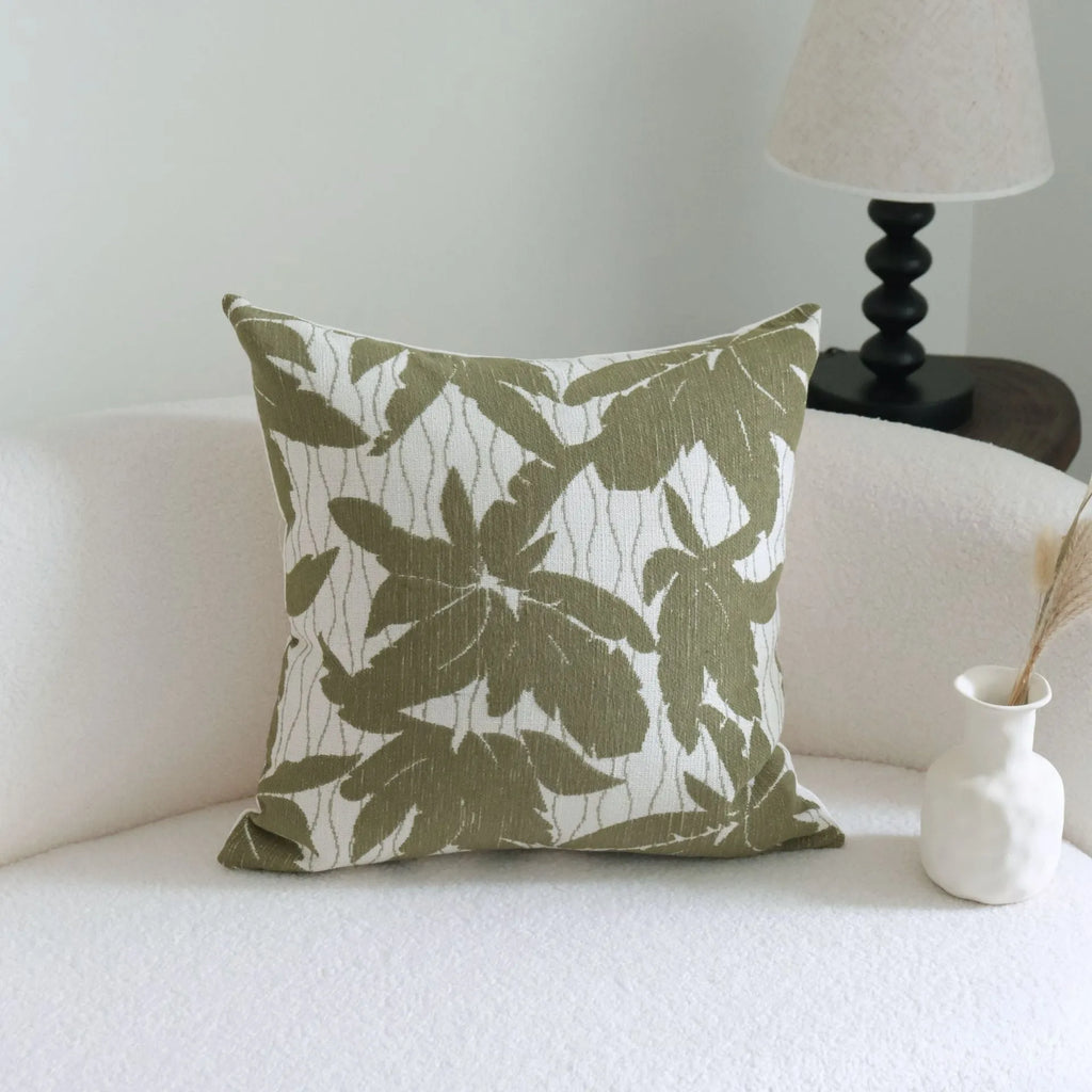Green cotton linen hotel sample pillow with tassel design and silk floss filling on bed.