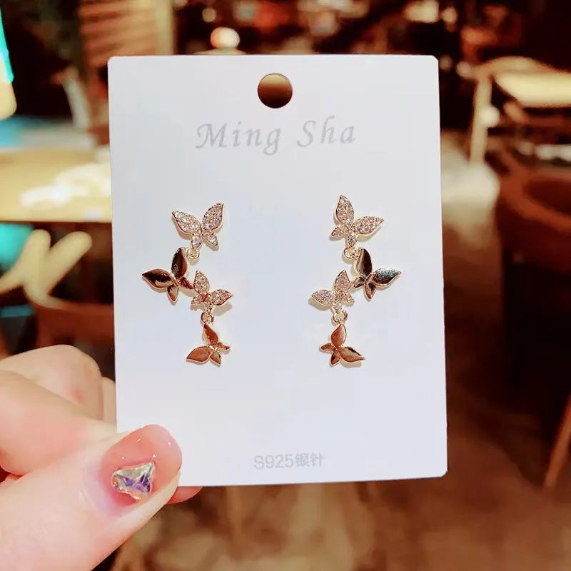 Gold colour butterfly earrings with four copper charms on hanging ear drops