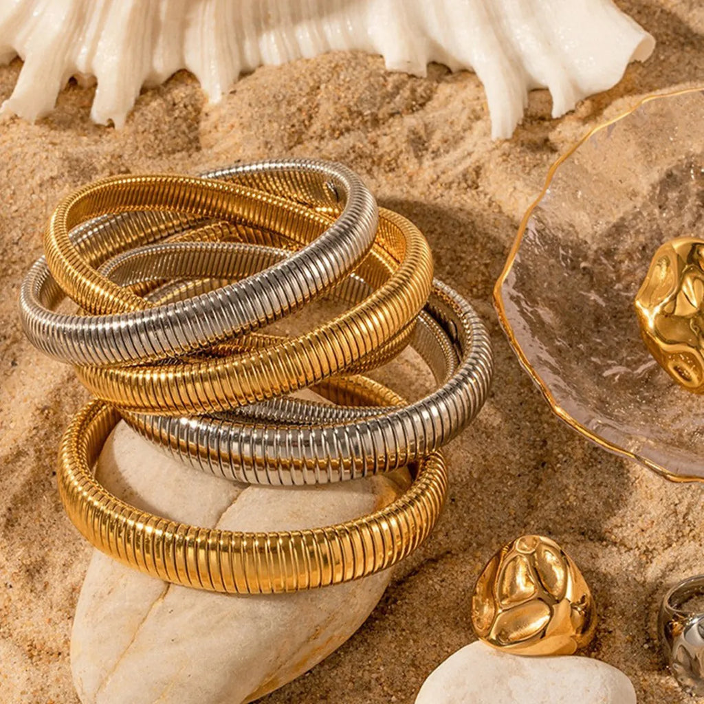 Women's titanium steel elastic bracelet with vertical stripe pattern and ring element in gold finish