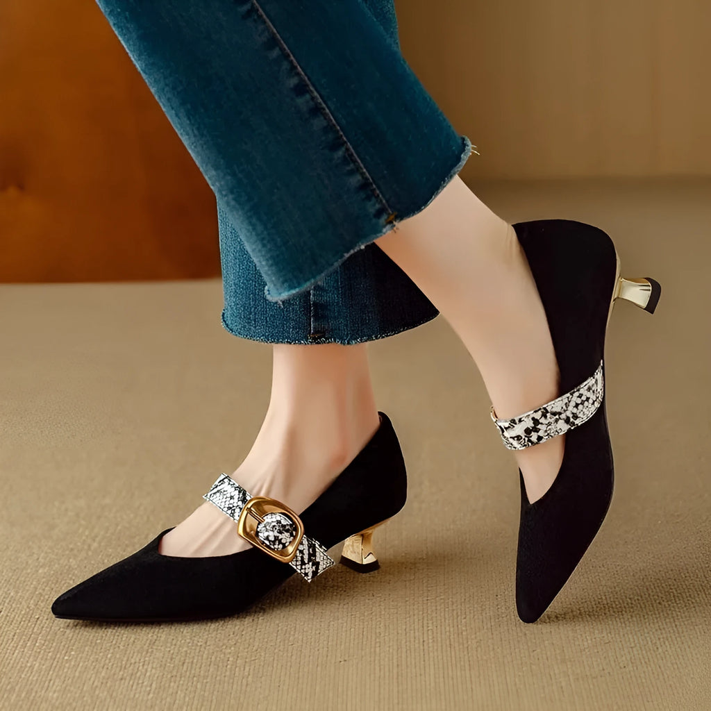 Black women's stiletto high heel shoes with buckle fastening and pointed toe on a solid background.