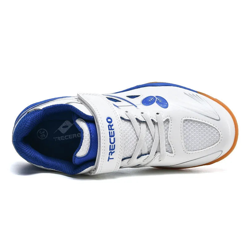 White and blue low-top breathable badminton shoes with ribbed sole on a court surface.
