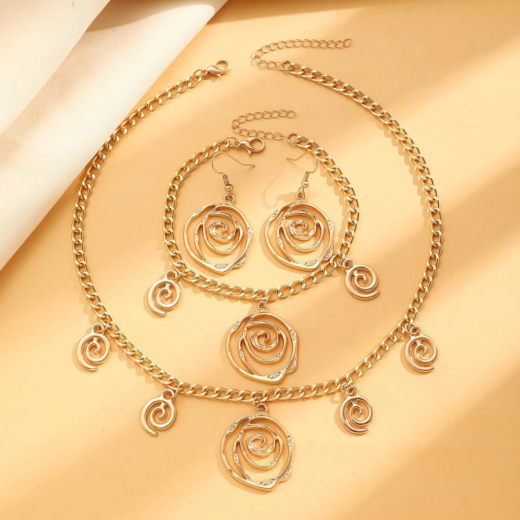 Gold tone donut spiral necklace, bracelet, and earrings set on a white background.