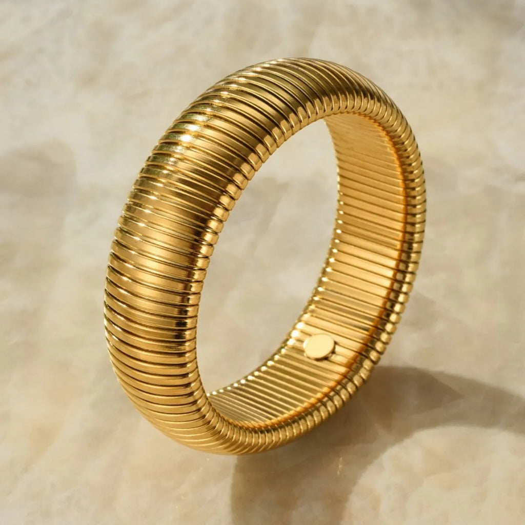 Women's titanium steel elastic bracelet with vertical stripe pattern and ring element in gold finish