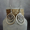 Silver geometric spiral earrings with a distressed retro finish, shown from the front.