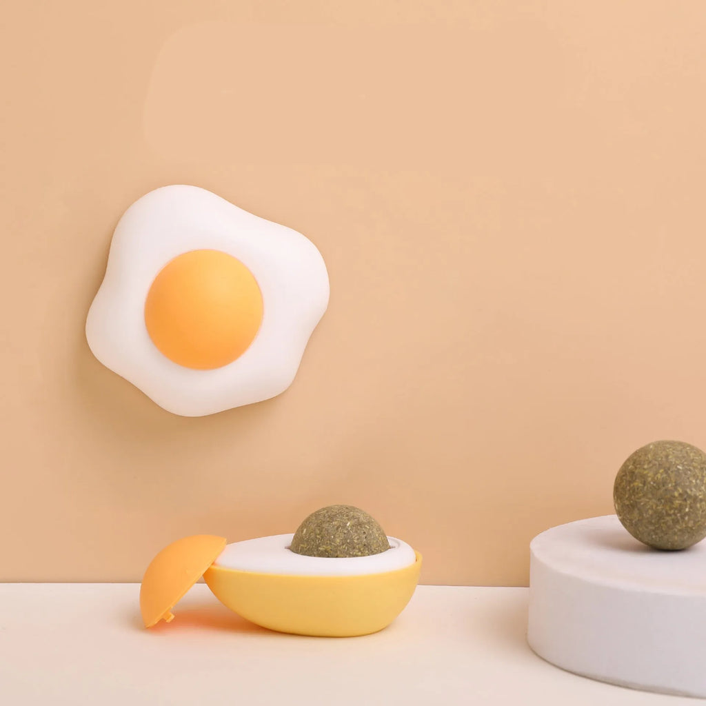 Interactive catnip ball toy with soft plush exterior mounted on wall for feline play