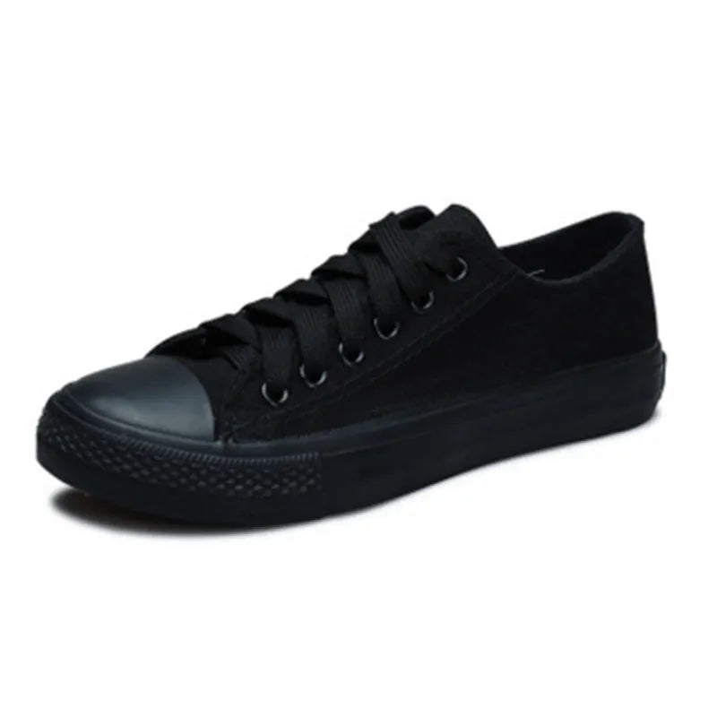 Women's solid colour canvas casual trainers in All Black, shown from the side on a white background.