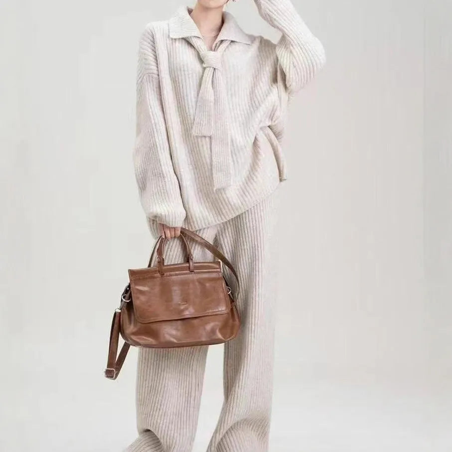 Beige acrylic imitation cashmere knitted top and trouser two-piece set on a hanger.