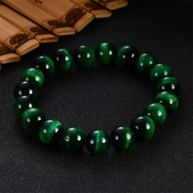 Green tiger eye stone bead bracelet with geometric polished beads on a wrist.