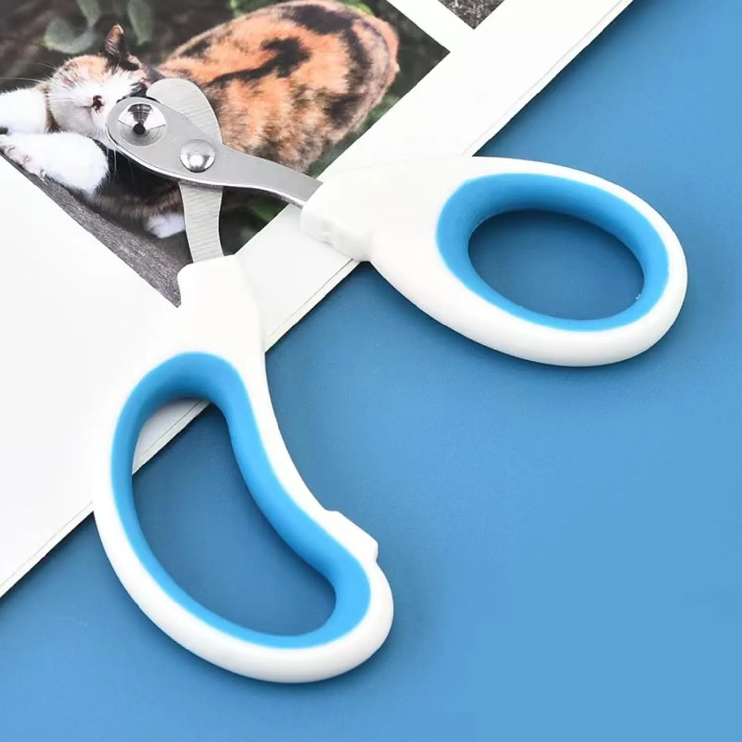Blue pet nail clippers with circular safety-guide hole and cushioned non-slip handles.