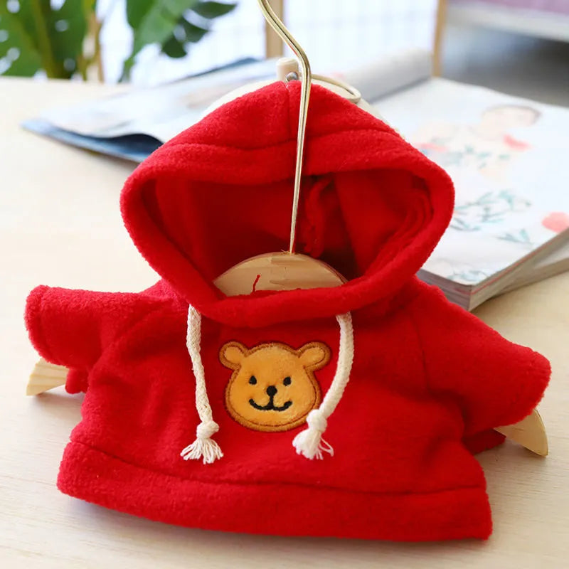 A blue cloth dog hoodie laid flat, showing its front and hood, with a net storage bag beside it.