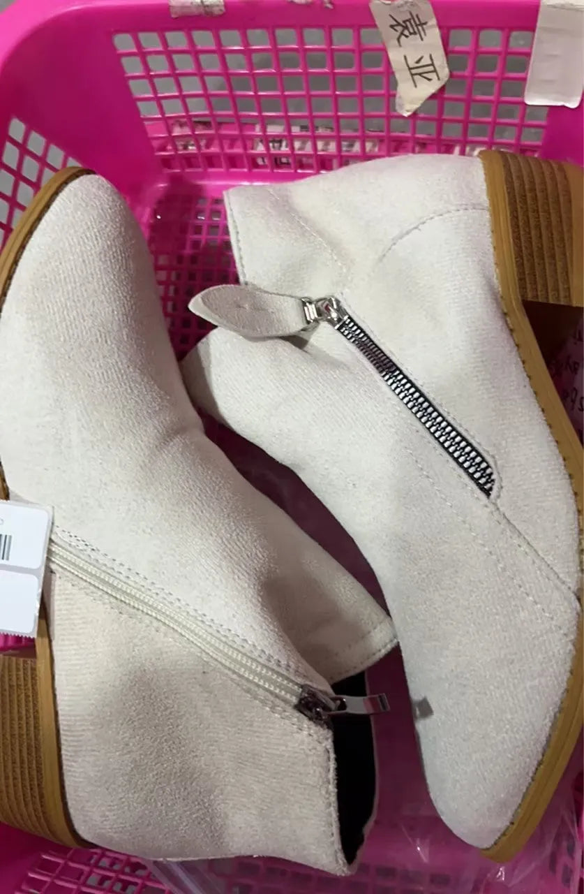 Women's beige suede ankle boots with a side zip and chunky block heel on a neutral background.