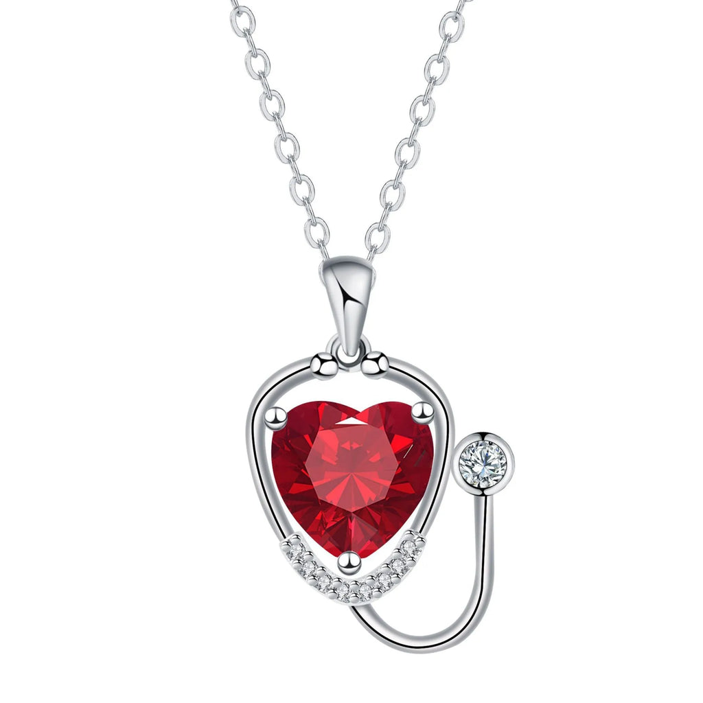 Red diamond women's necklace with a stethoscope, wings, and cross pendant on an adjustable chain.