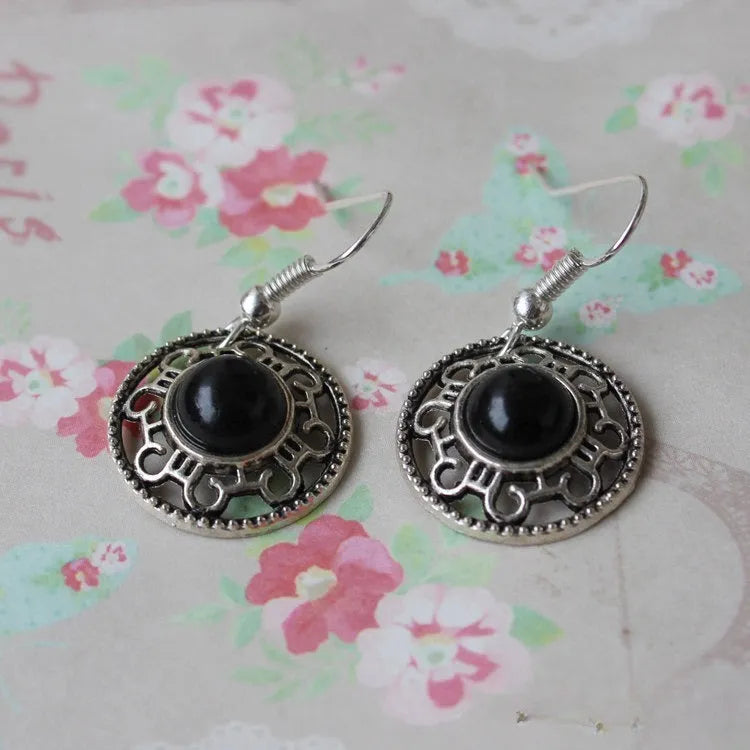 Handmade geometric flower disk earrings in Tibetan silver and turquoise, showing totem patterns.