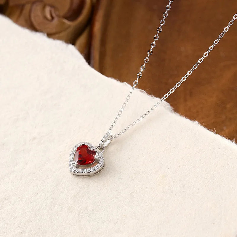 Women's sterling silver heart pendant necklace with natural gemstone on a cross chain.