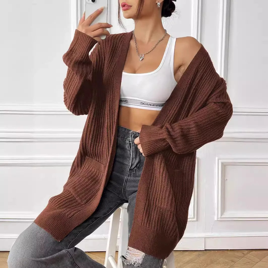 Women's dark green loose-fit acrylic cardigan with double pockets and long sleeves.