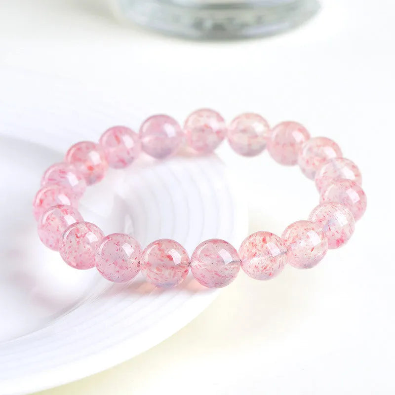 Natural white strawberry quartz crystal ball bracelet with 10mm spherical beads on wrist.