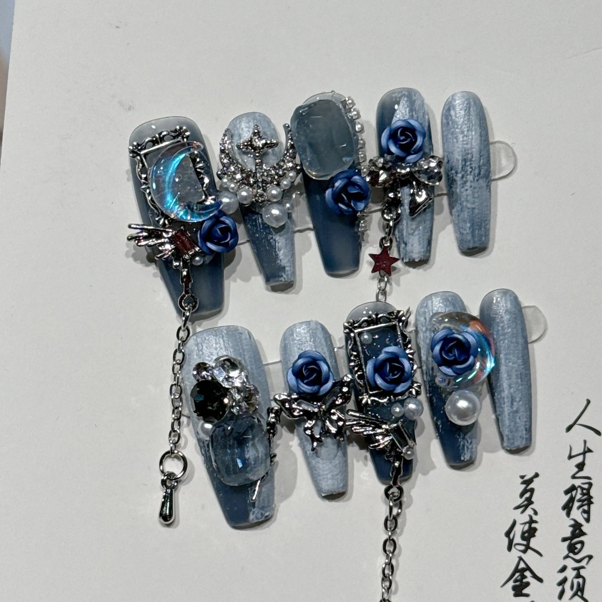 False nails with heavy industry blue colour and ornate rose and tulip flower patterns.