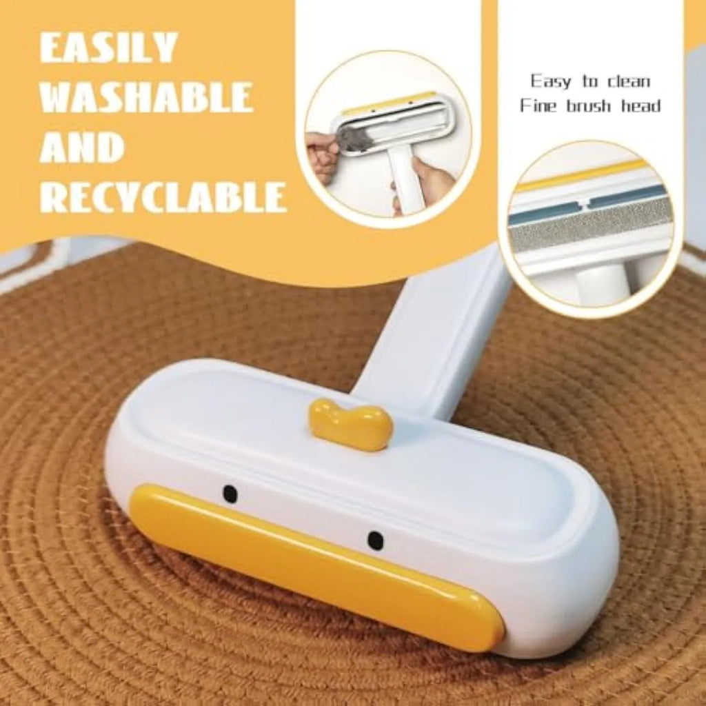 Yellow duck design portable manual pet hair remover tool on a fabric surface.