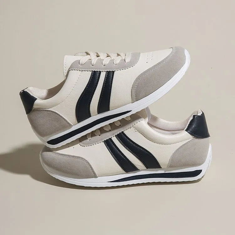 Red and blue low-top lace-up sneakers with rubber sole and mesh upper on white background