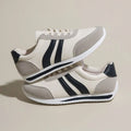 Red and blue low-top lace-up sneakers with rubber sole and mesh upper on white background