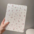 Transparent floral patterned tri-fold hard case for Apple iPad showing stand angle.