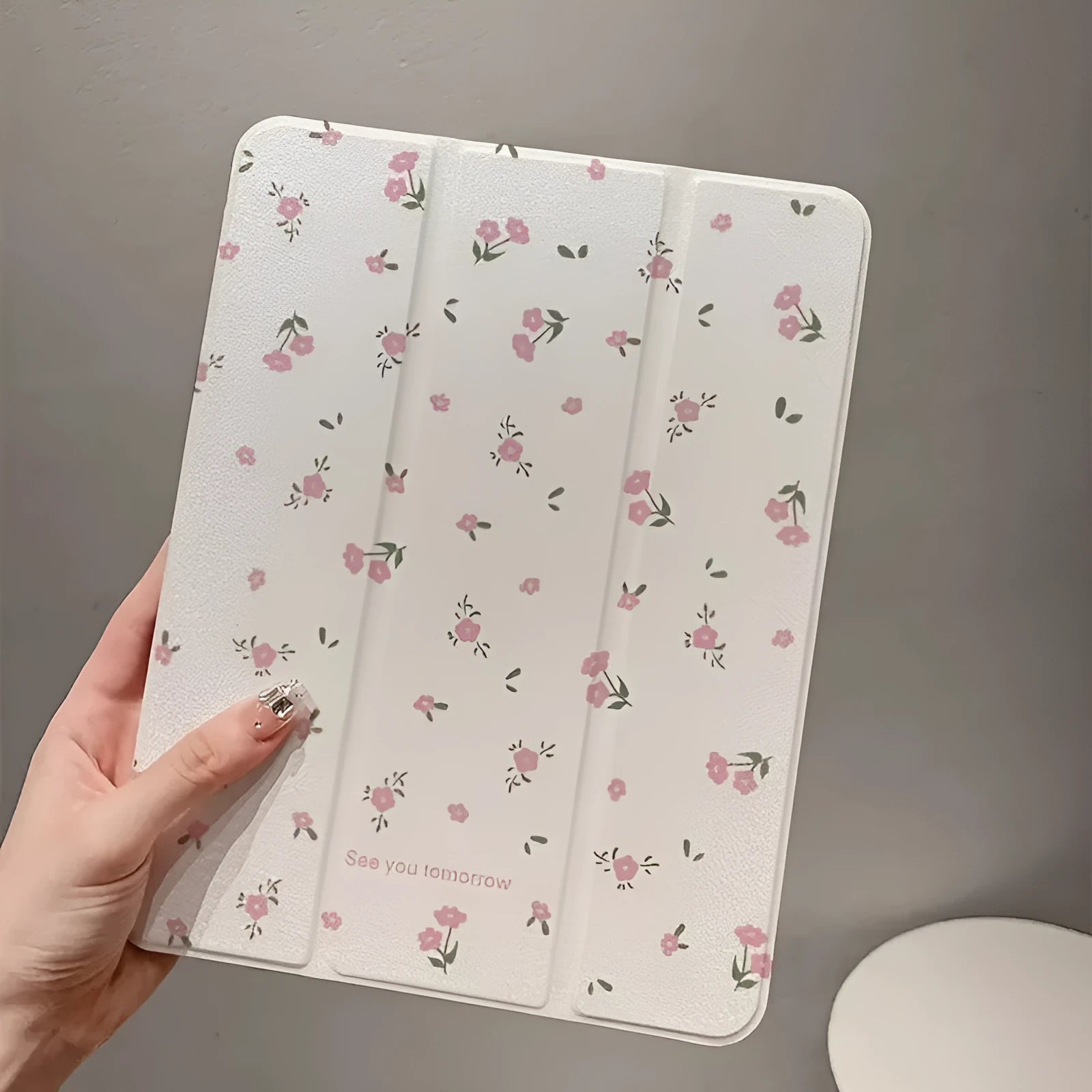 Transparent floral patterned tri-fold hard case for Apple iPad showing stand angle.
