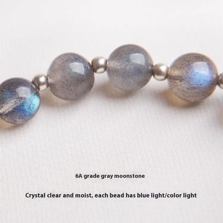 Silver grey women's bracelet with honeysuckle pattern, moonlight crystals, and a small zodiac charm.