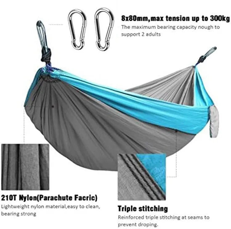 Blue outdoor camping hammock hanging between trees with ropes and carabiners