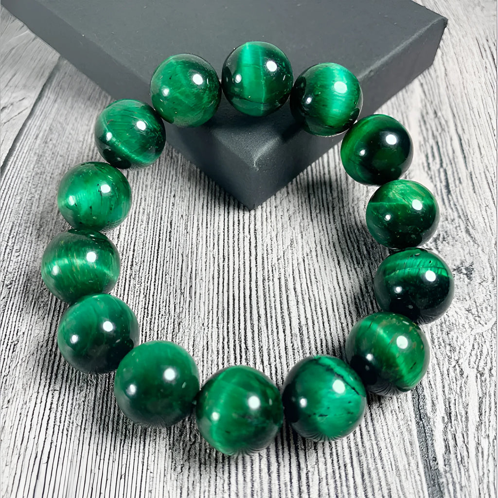 Green tiger eye stone bead bracelet with geometric polished beads on a wrist.