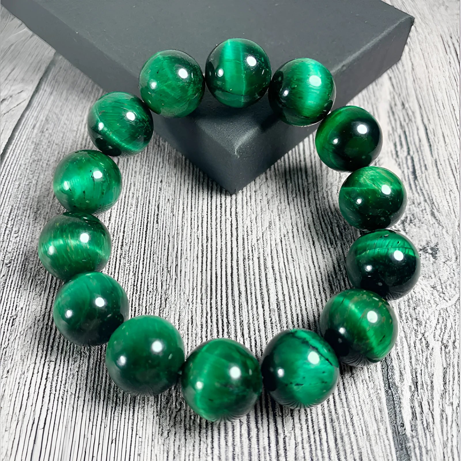Green tiger eye stone bead bracelet with geometric polished beads on a wrist.