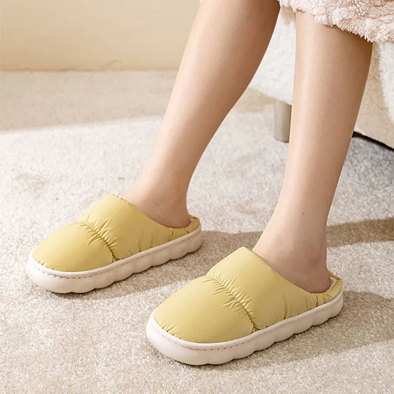 Pair of down cotton winter slippers with artificial leather upper, plush lining, and thick rubber sole.