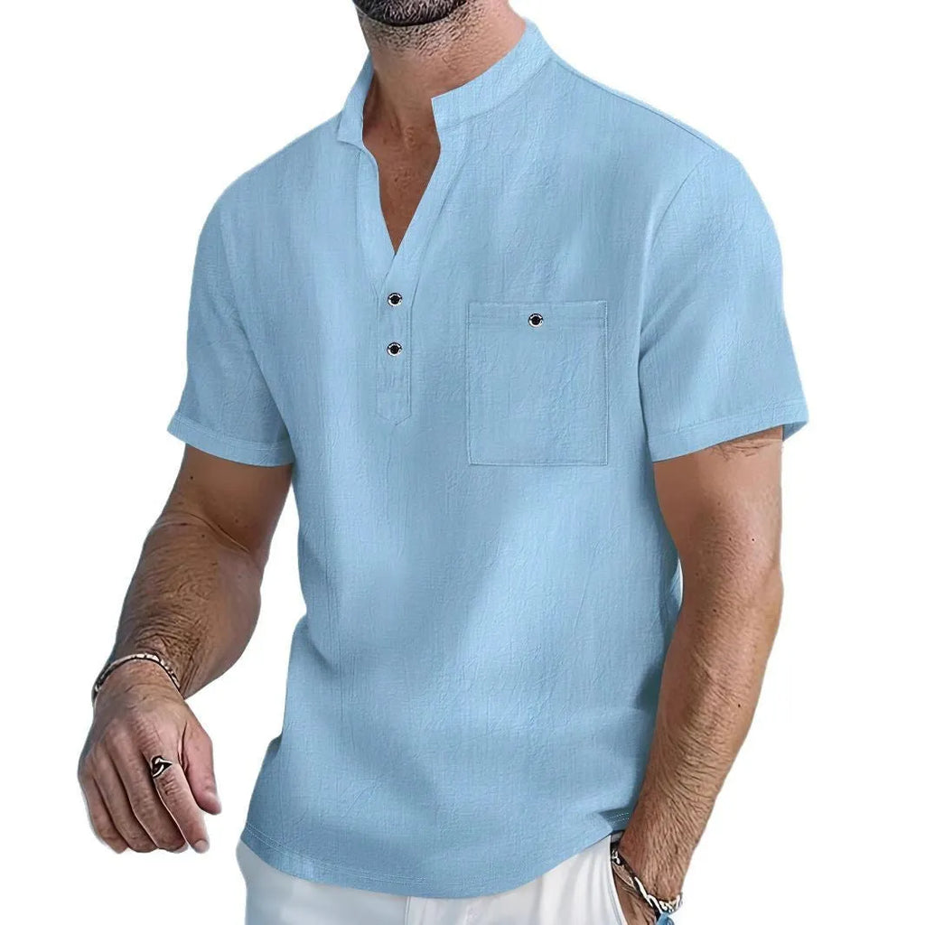 Man wearing a light apricot-coloured linen short sleeve shirt with a stand collar.