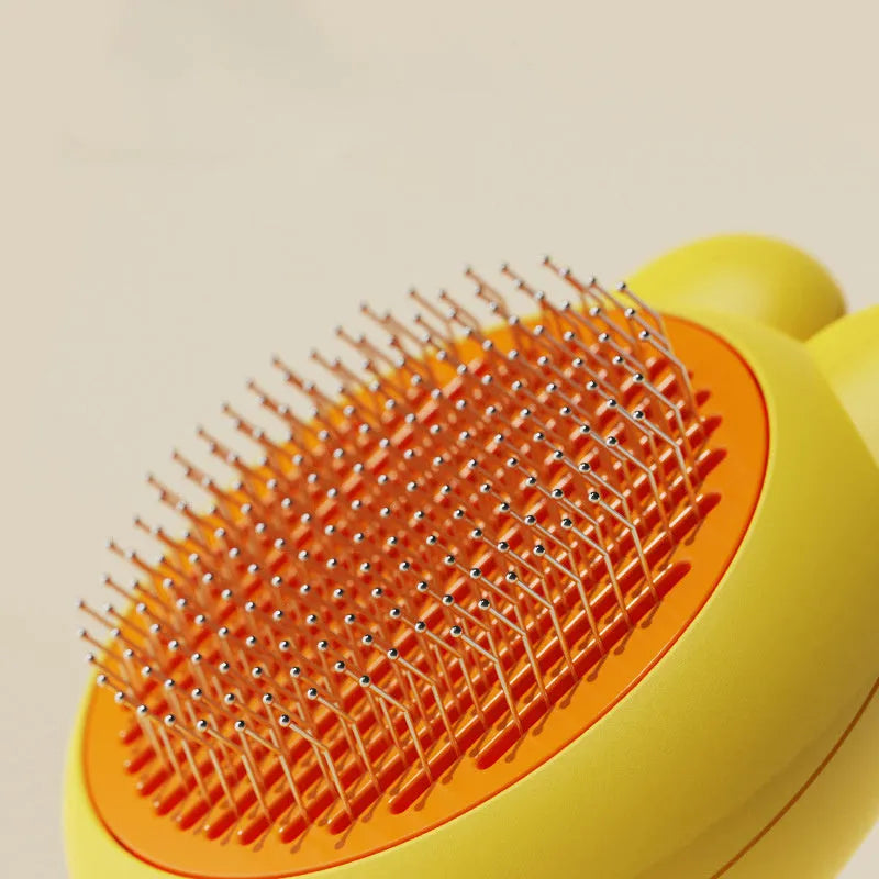 Self-cleaning pet grooming brush with coloured handle and stainless steel comb teeth