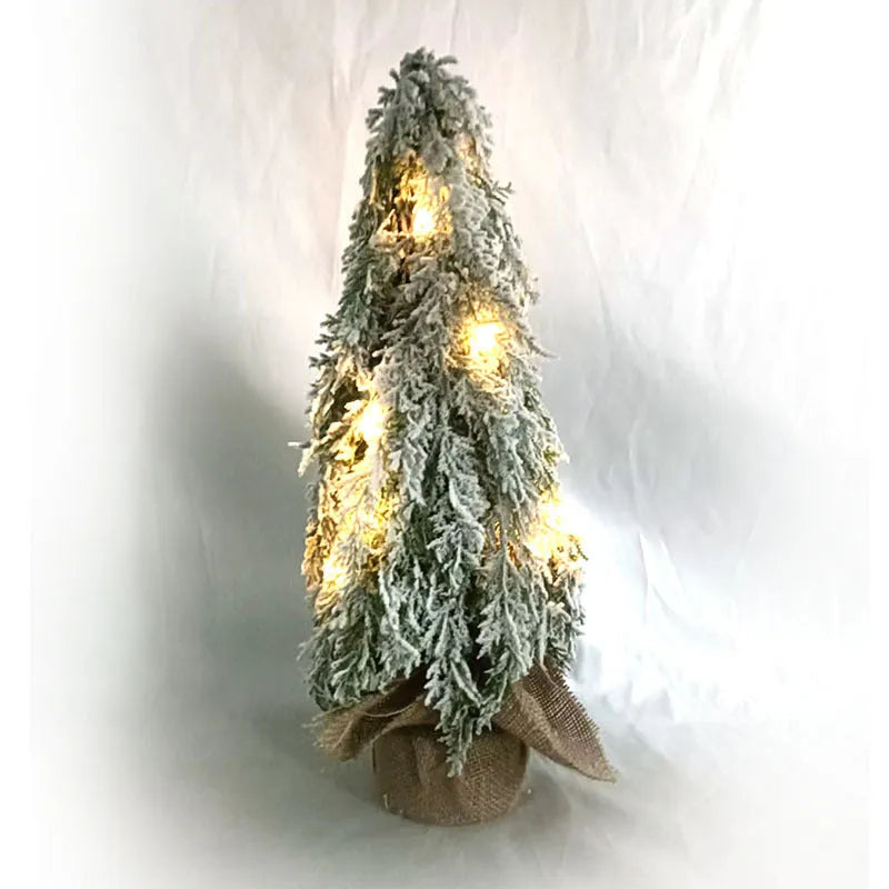Small 24 inch artificial Christmas tree with lights and snow effect on a desktop