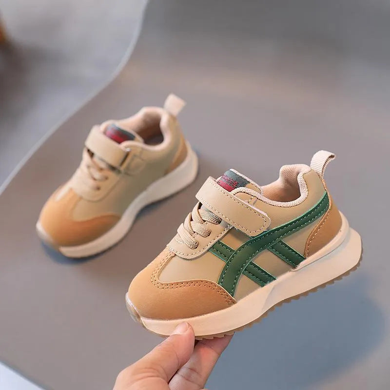 Children's solid-colour sneakers with Velcro strap in white, beige, or khaki on a rubber sole.