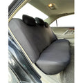 Set of blue polyester car seat covers with eyelet stitching on a vehicle seat.