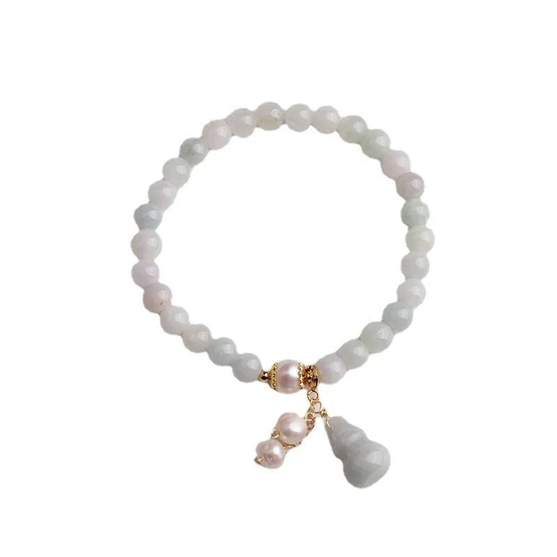 Close-up of a natural emerald jade bracelet with a handcrafted gourd design in Chinese style.