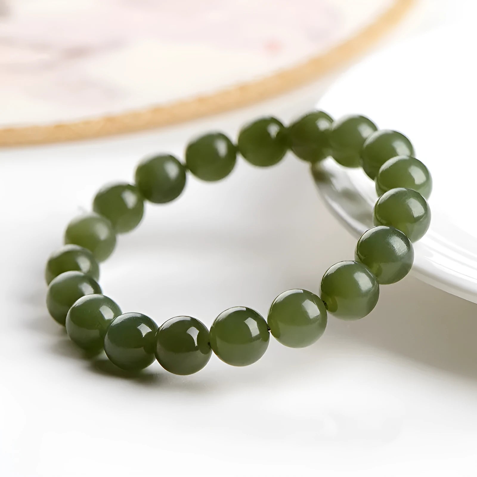 Polished Hetian Jade ball bracelet in clear water colour on a wrist, showing multiple bead sizes.