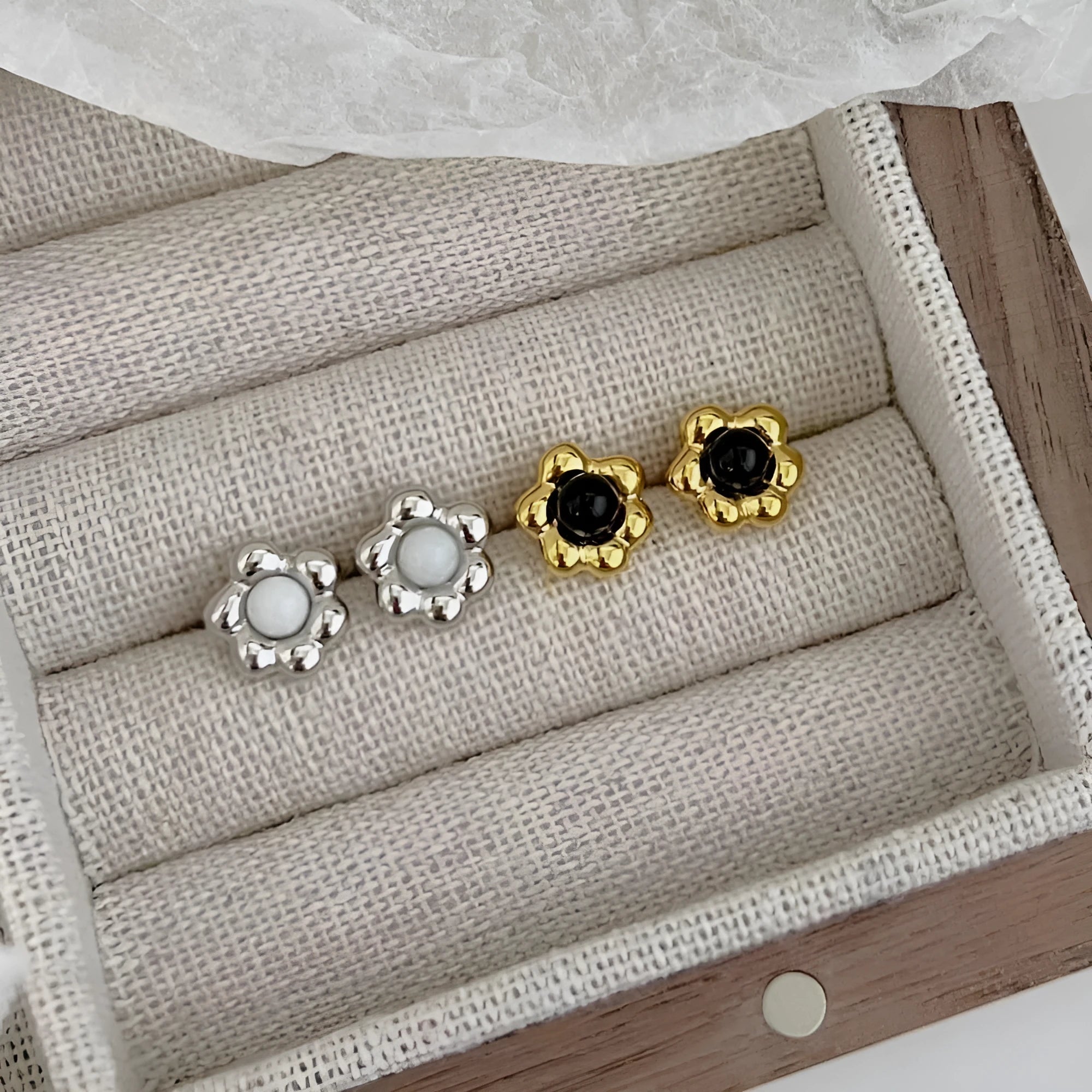 S925 sterling silver black agate flower ear studs in gold colour on a woman's ear
