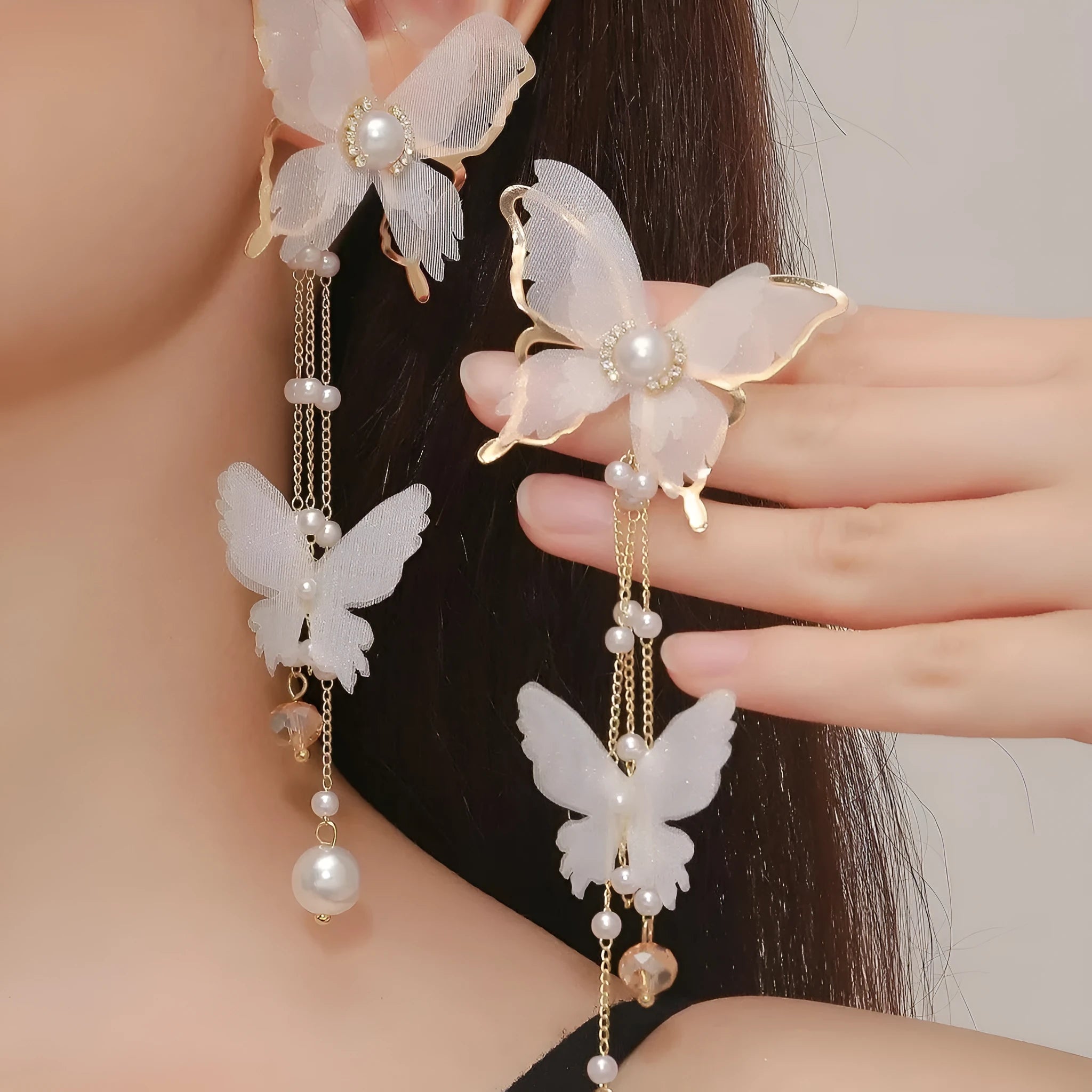 White butterfly-shaped earrings with lace patterns, pearl accents, rhinestone details, and tassel elements on copper alloy