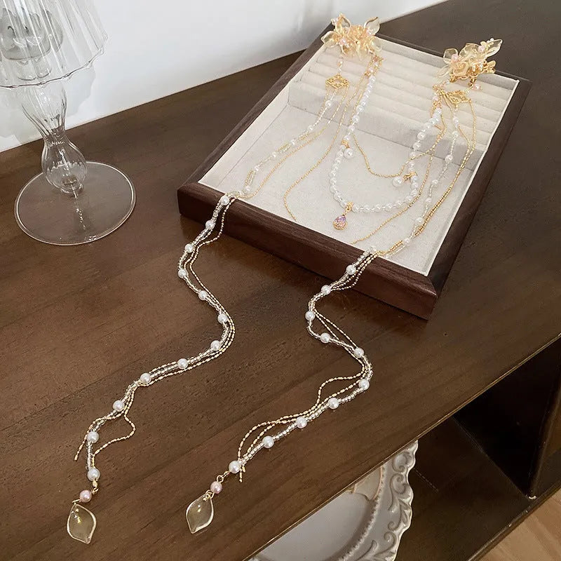 Gold acrylic hairpin with pearl, diamond, and long tassel decorative elements for women's hairstyling.